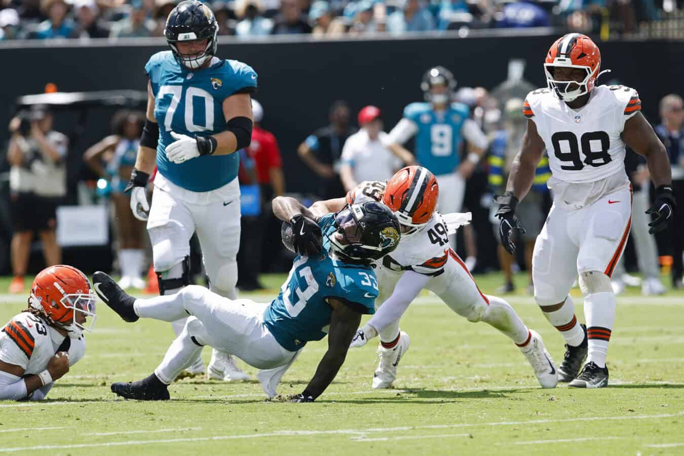 JACKSONVILLE, FLORIDA - SEPTEMBER 13: Bhayshul Tuten #33 of the Jacksonville Jaguars is tackled by Carson Schwesinger #49 of the Cleveland Browns during the first half of the game at EverBank Stadium on September 13, 2026 in Jacksonville, Florida.