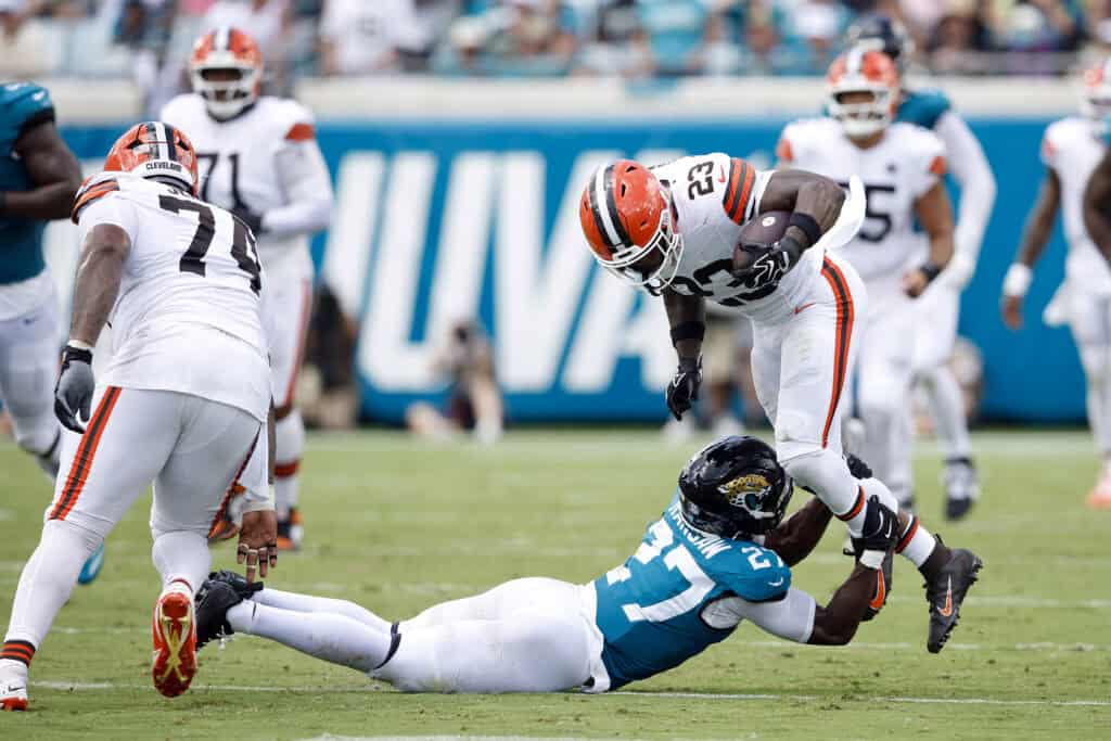 JACKSONVILLE, FLORIDA - SEPTEMBER 13: Raheim Sanders #23 of the Cleveland Browns is tackled by Caleb Ransaw #27 of the Jacksonville Jaguars during the first half of the game at EverBank Stadium on September 13, 2026 in Jacksonville, Florida.