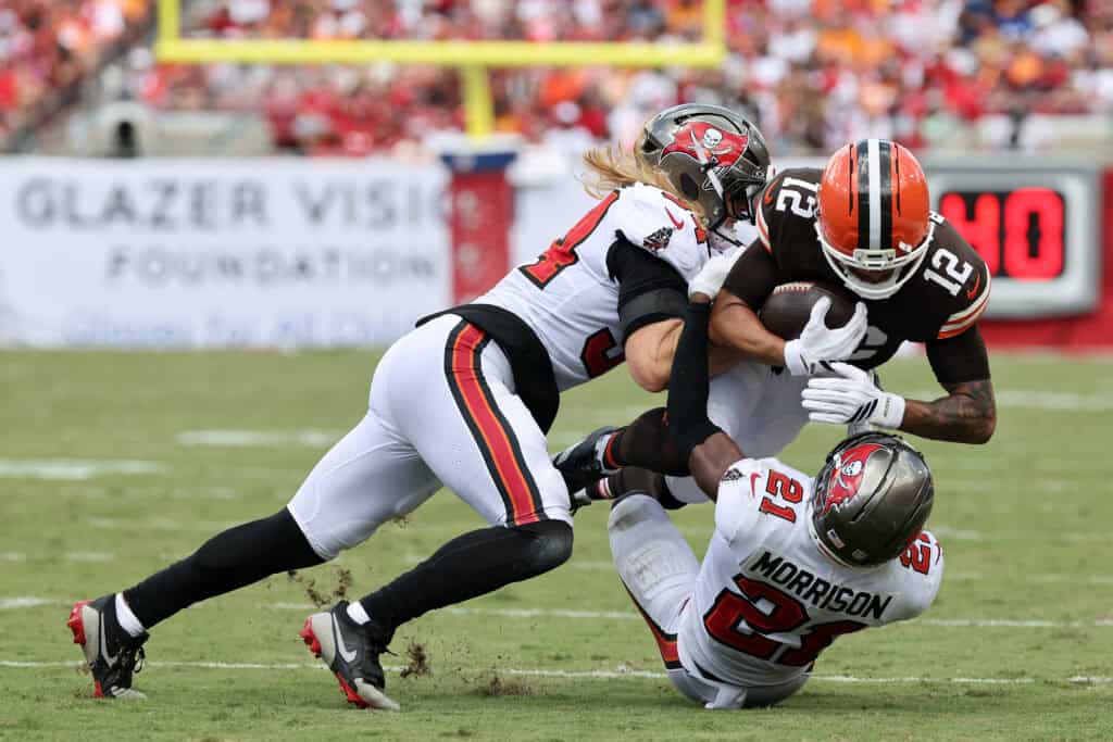 TAMPA, FLORIDA - SEPTEMBER 20: Denzel Boston #12 of the Cleveland Browns is tackled by Calijah Kancey #94 of the Tampa Bay Buccaneers and Benjamin Morrison #21 during the first half of the game at Raymond James Stadium on September 20, 2026 in Tampa, Florida.