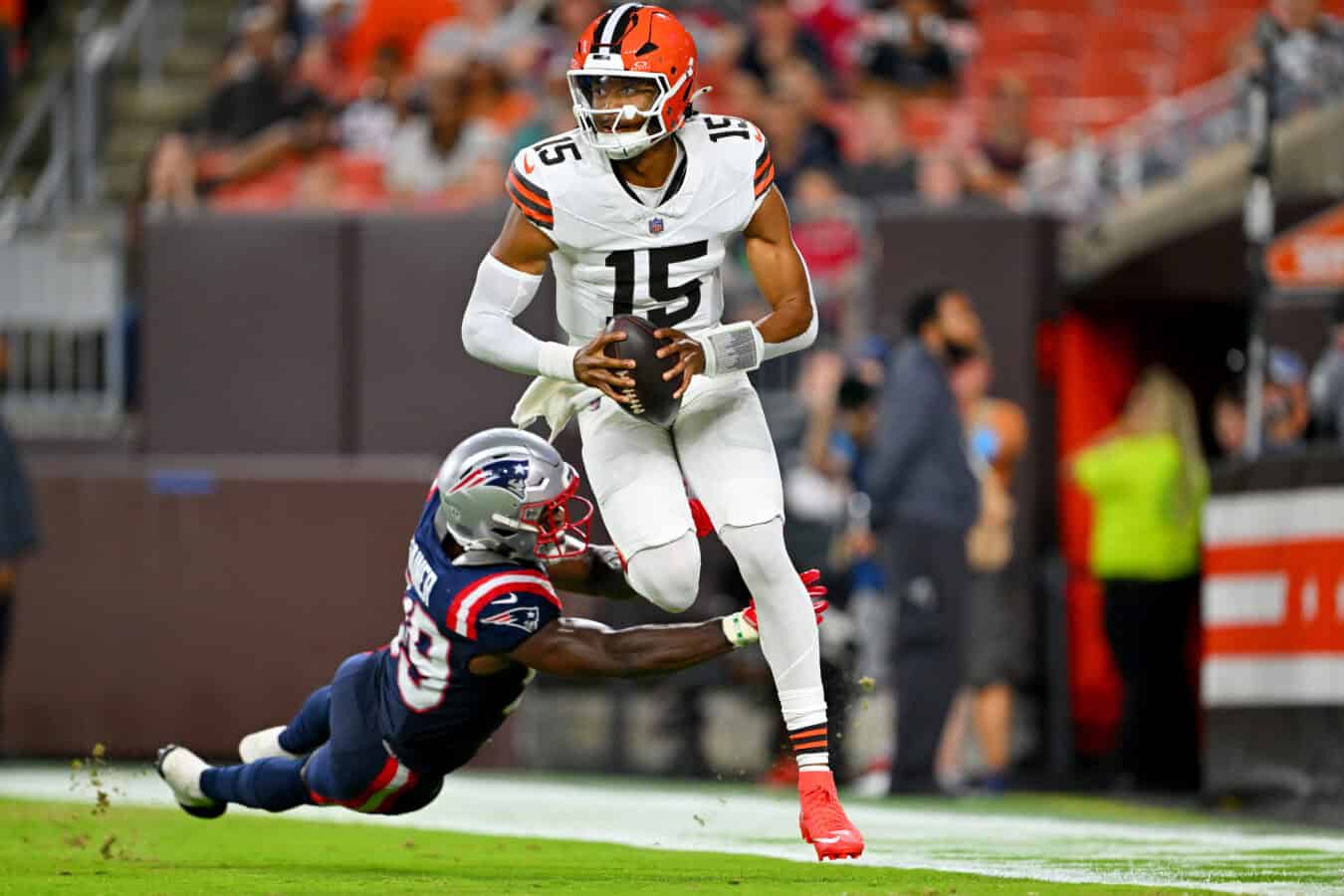 CLEVELAND, OHIO - AUGUST 27: Quarterback Taylen Green #15 of the Cleveland Browns avoids linebacker Amari Gainer #99 of the New England Patriots during the third quarter of a preseason game at Huntington Bank Field on August 27, 2026 in Cleveland, Ohio. The Browns defeated the Patriots 37-13.