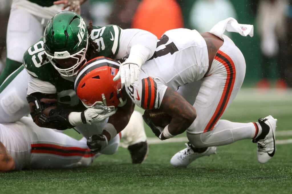 EAST RUTHERFORD, NEW JERSEY - OCTOBER 11: Quinshon Judkins #10 of the Cleveland Browns is tackled by T'vondre Sweat #99 of the New York Jets during the third quarter of the game at MetLife Stadium on October 11, 2026 in East Rutherford, New Jersey.