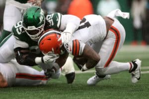 EAST RUTHERFORD, NEW JERSEY - OCTOBER 11: Quinshon Judkins #10 of the Cleveland Browns is tackled by T'vondre Sweat #99 of the New York Jets during the third quarter of the game at MetLife Stadium on October 11, 2026 in East Rutherford, New Jersey.