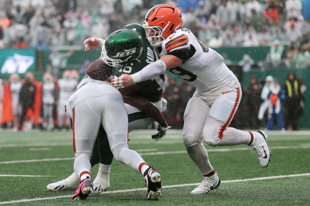 EAST RUTHERFORD, NEW JERSEY - OCTOBER 11: Quincy Williams #5 and Carson Schwesinger #49 of the Cleveland Browns break up a pass intended for Kenyon Sadiq #16 of the New York Jets during the third quarter of the game at MetLife Stadium on October 11, 2026 in East Rutherford, New Jersey.
