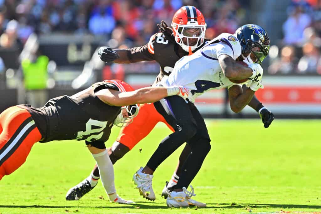 CLEVELAND, OHIO - OCTOBER 18: Zay Flowers #4 of the Baltimore Ravens runs the ball against Emmanuel McNeil-Warren #28 and Carson Schwesinger #49 of the Cleveland Browns during the second quarter of the game at Huntington Bank Field on October 18, 2026 in Cleveland, Ohio.