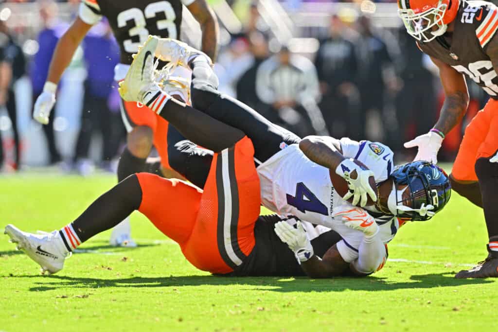 CLEVELAND, OHIO - OCTOBER 18: Zay Flowers #4 of the Baltimore Ravens is tackled by Emmanuel McNeil-Warren #28 and Carson Schwesinger #49 of the Cleveland Browns during the second quarter of the game at Huntington Bank Field on October 18, 2026 in Cleveland, Ohio.